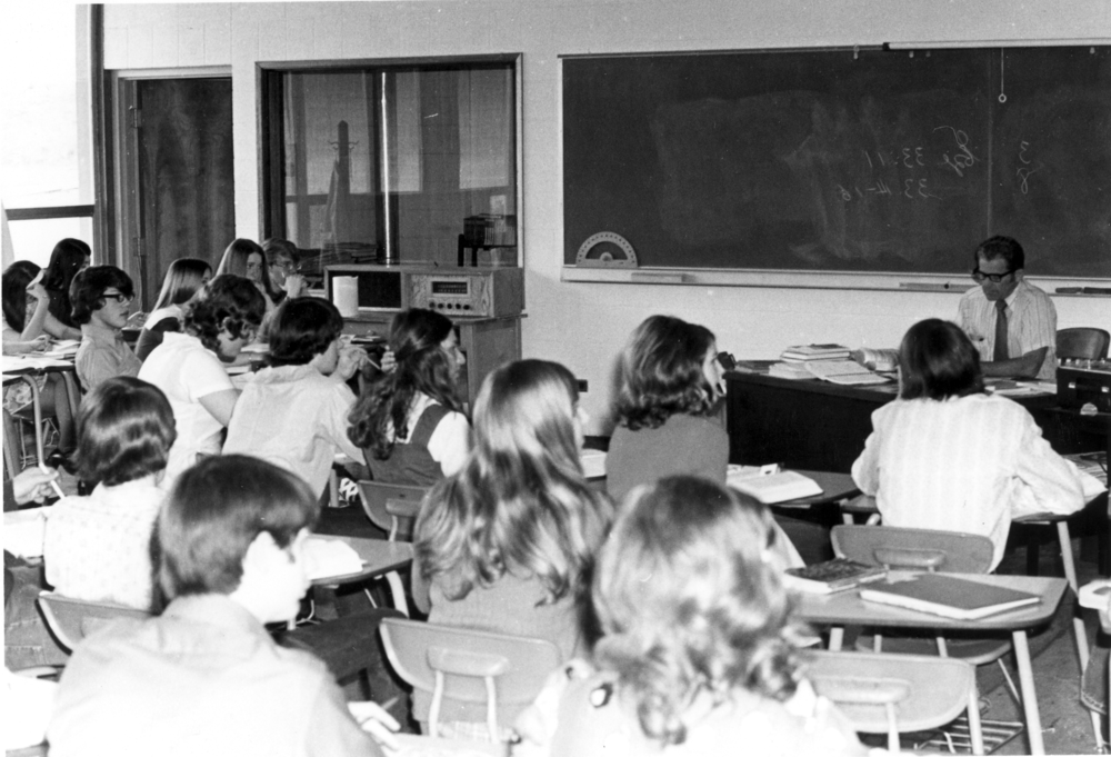 爱德华·埃德斯特罗姆(Edward Edstrom)在一所学院教室的讲台上教书.